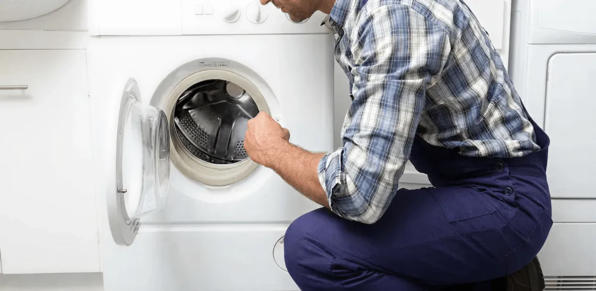 Handyman inspecting a dryer drum and internal parts for repair in Chandler, AZ