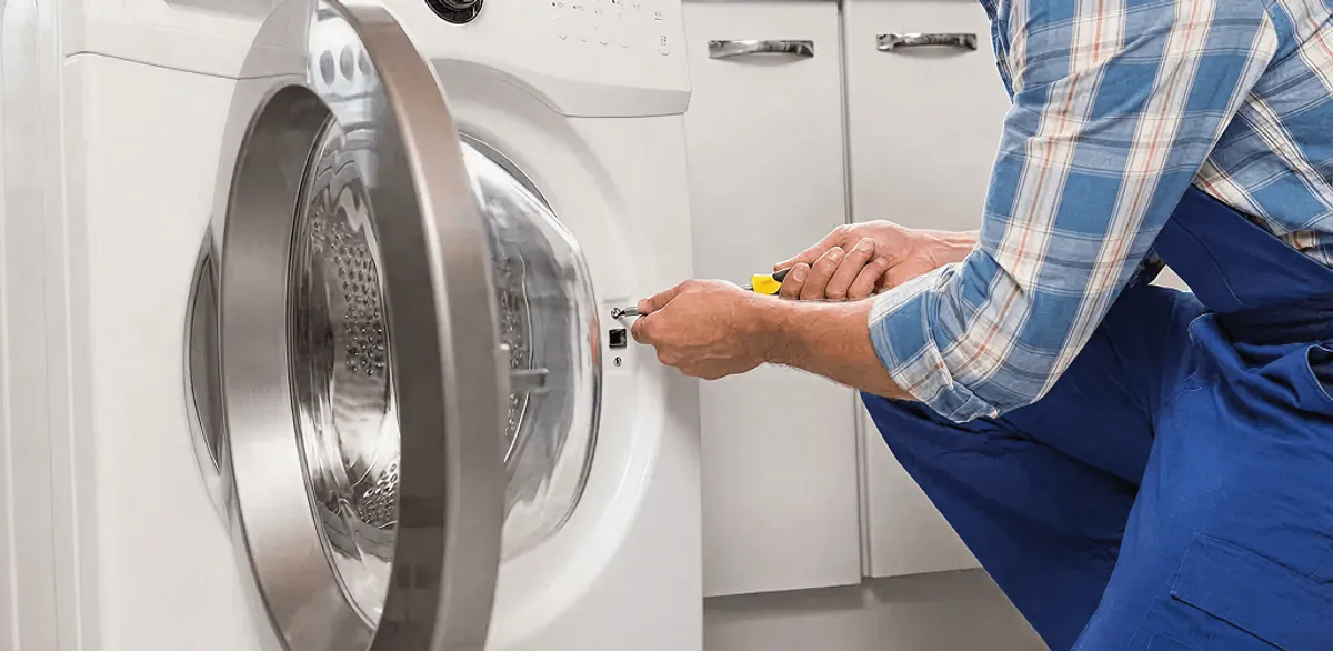 Handyman repairing a clothes dryer and checking electrical connections in Chandler, AZ