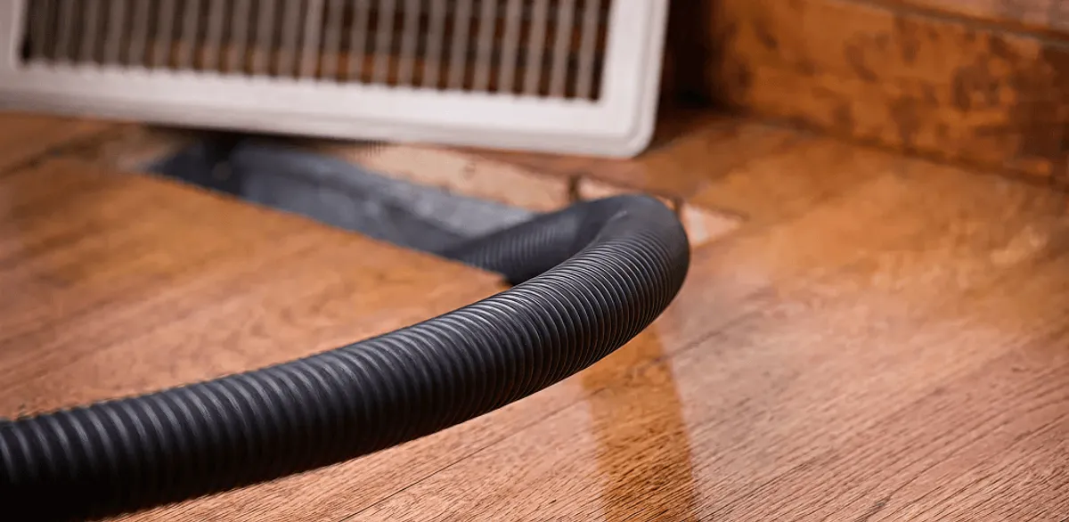 Air duct cleaning hose inserted into a floor vent for ductwork cleaning in Chandler, AZ