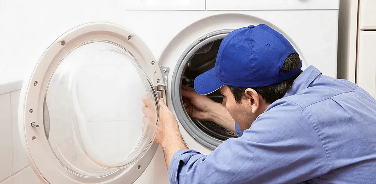 Washing machine repair handyman inspecting a front-load washer drum in Chandler, AZ