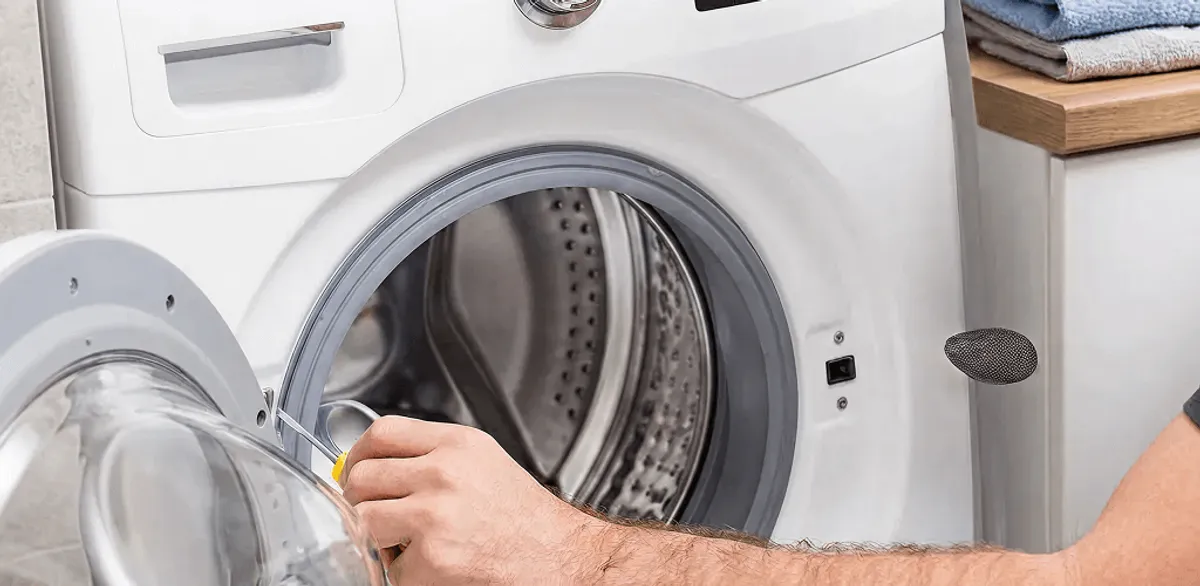 Handyman repairing a front-load washing machine and inspecting the drum in Chandler, AZ